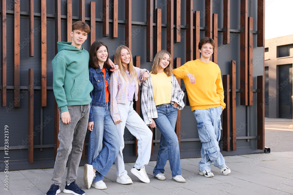Obraz premium Group of teenagers near building on city street