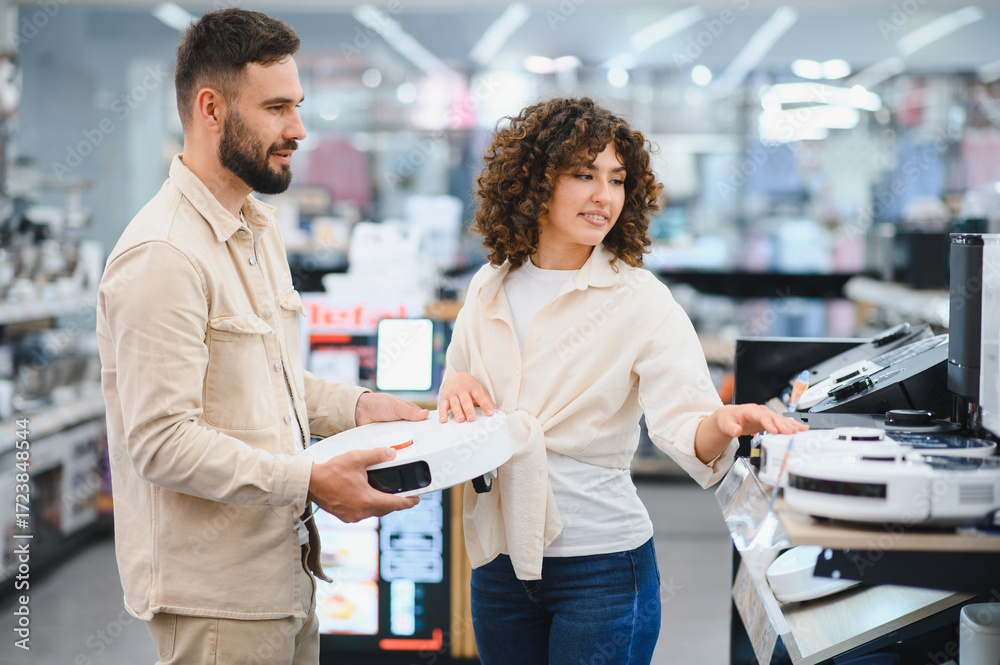 Obraz premium Couple choosing robotic vacuum cleaner in electronics store