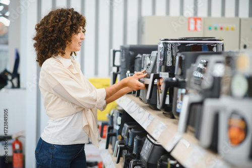 Foto Woman choosing kitchen appliances in electronics store