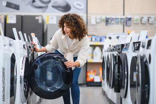 Fotografía Woman choosing washing machine in electronics store