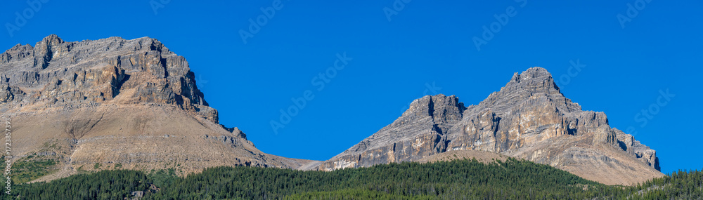 Fototapeta premium Panorama of spectacular rocky mountain range with clear blue sky 