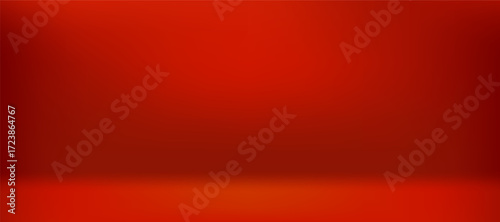 Empty red studio background for product display. Red room with a smooth floor and wall, illuminated by a soft spotlight with a dark vignette border