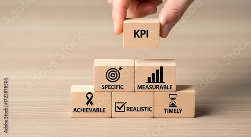 Hand stacking wooden blocks with kpi acronym and smart criteria for business goals and objectives