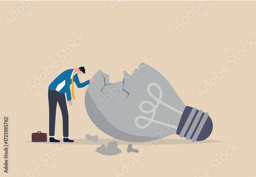 Uninspired or motivation after business failure, burnout or exhausted from crisis, no new idea or inspiration concept, depressed business man sadly standing with fail old broken lightbulb idea. 