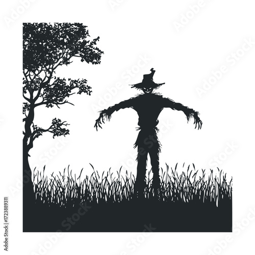 Silhouette of a creepy scarecrow and a tree in a field of grass.  