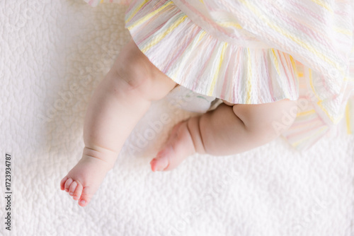 A baby has very fat legs and chunky feet
