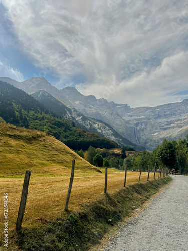 Obraz na płótnie Stunning landscape of Cirque de Gavarnie showcases majestic mountains and open fields under a bright sky