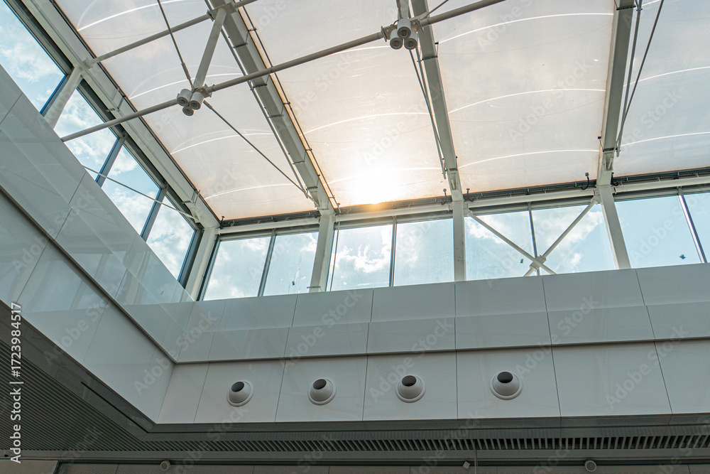 Fototapeta premium Spacious interior with multiple skylights, translucent glass panels, light walls, and even illumination Empty room, minimalistic design, potentially for various functions such as exhibition hall or
