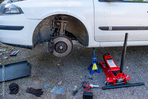The car is prepared for changing wheels, lifted on a jack and placed next to the car.