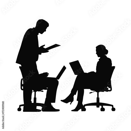 Silhouette of two business professionals collaborating on laptops in an office setting