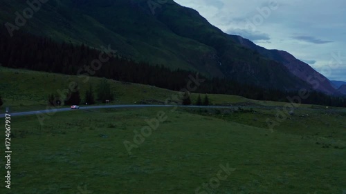 Aerial view of a car driving along a mountain road