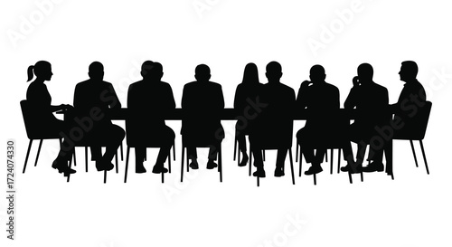 Group of people seated around a table in dark silhouette