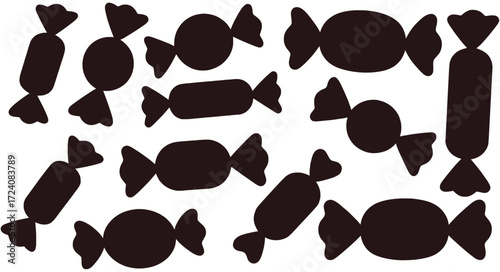 Dark brown candy wrappers scattered on white background sweets silhouette