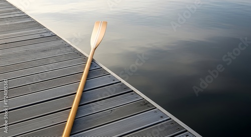 Wallpaper Mural Minimal wooden rowing oar resting on pier with calm water background Torontodigital.ca