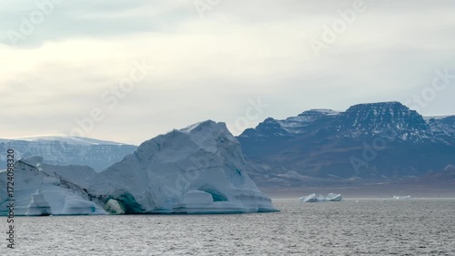 Wallpaper Mural Iceberg floating peacefully in the calm waters near mountainous terrain at dawn in a remote Arctic region Torontodigital.ca