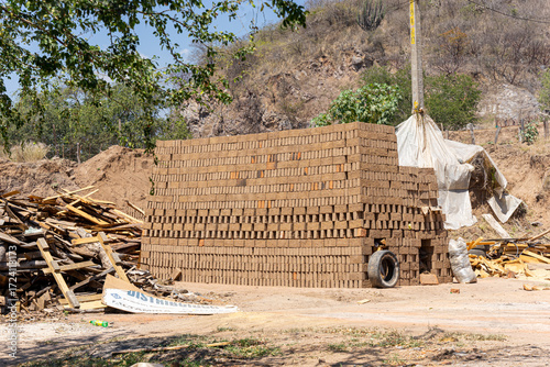 Kiln for firing of handmade bricks, pile of raw bricks drying in the sun, artesanal clay brick production. Guadalajara, Jalisco, March 29 2024.