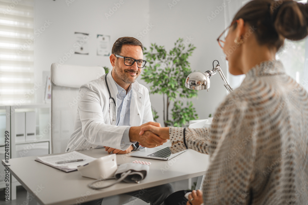 Obraz premium Doctor shaking patient hand during office consultation