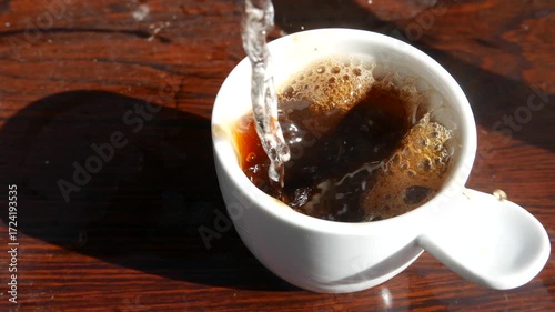 POV: Someone serving coffee. Pouring a cup of instant coffee. Coffee bubbles popping in a cup. Drinking coffee.