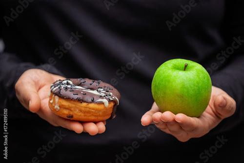 healthy and unhealthy diet concept with green apple and sweet sugary donut