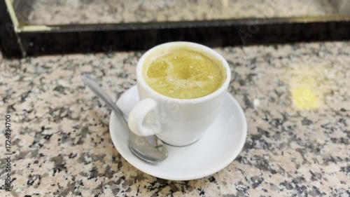 Close-up of hot coffee served in a white cup with saucer on a rustic marble counter, capturing warm morning vibes, caffeine energy, and café lifestyle.