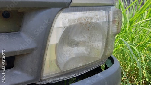 Bild auf Leinwand Headlight lens of old car showing dull plastic surface and slight yellowish haze