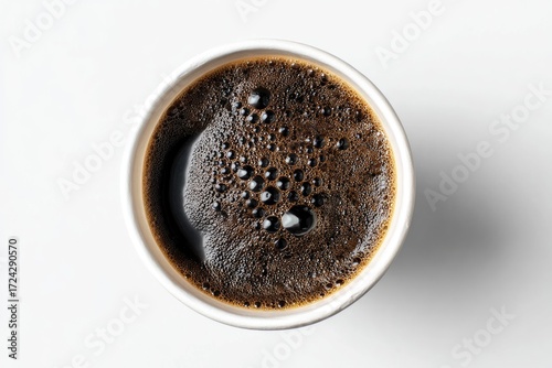 Top-down view of a disposable coffee cup filled with dark coffee
