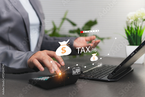 Tax concept calculation for planning deductions and refunds each year. Businesswoman using a calculator and laptop device, analyzing with a group of virtual accounting-related icons on screen.