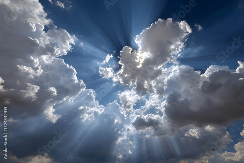 Fototapeta Naklejka Na Ścianę i Meble -  Sunlight breaking through scattered clouds on a clear blue sky during midday