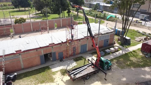 construction worker climbing scaffolding inside building under construction