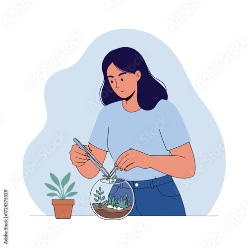 Woman arranging plants in a round glass terrarium with tweezers