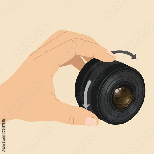 A hand holds a camera lens and adjusts it with rotation arrows