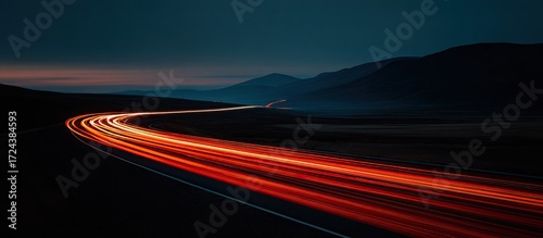Winding road at night, illuminated by car lights