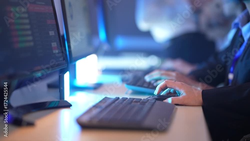 In a modern, blue-lit office, professionals' hands fly across keyboards, showcasing a high-speed digital workflow, intense data processing, and corporate workforce productivity.