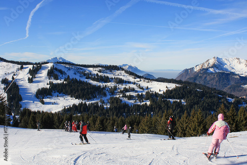 Canvas Print Group of skiers enjoying sunny day on snowy slopes of Morzine ski resort in the French Alps