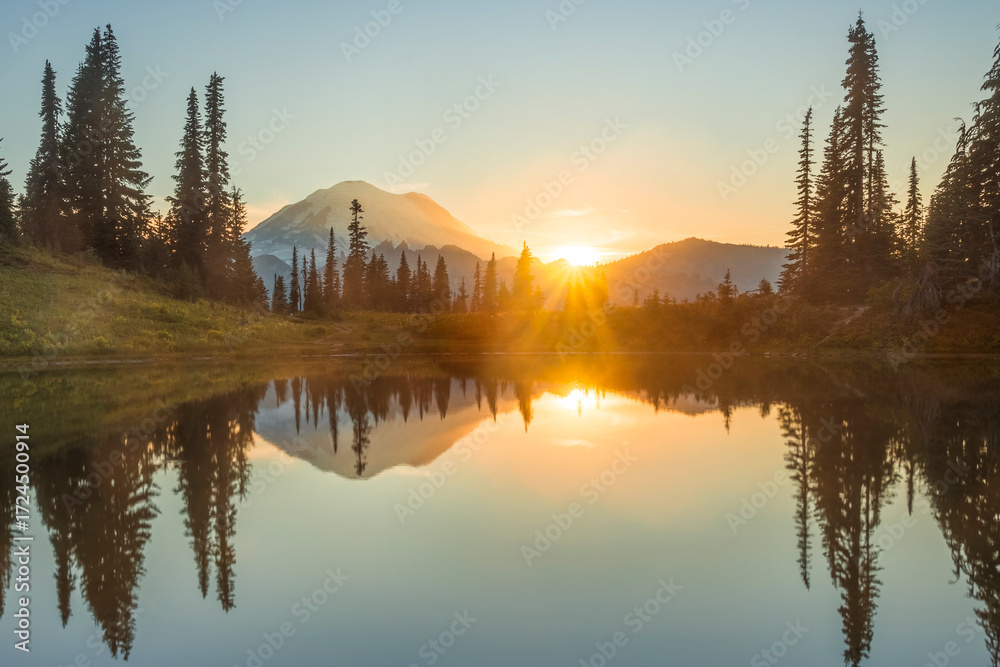 Obraz premium Sunburst over Mount Rainier seen reflecting off Little Tipsoo Lake at sunset