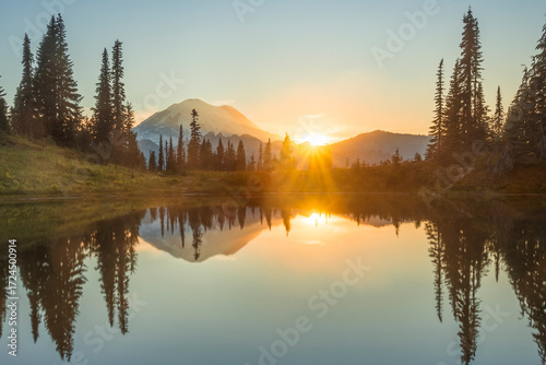 Sunburst over Mount Rainier seen reflecting off Little Tipsoo Lake at sunset