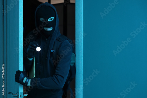 Male thief with flashlight ...