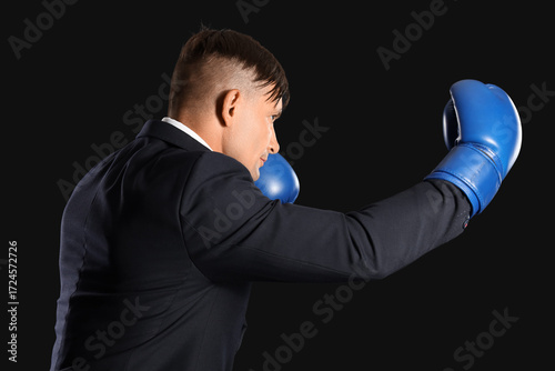 Male boxer in suit on dark ...