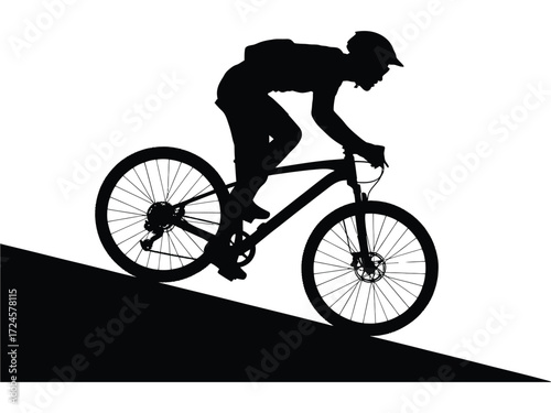 Silhouette of a mountain biker descending a steep hill