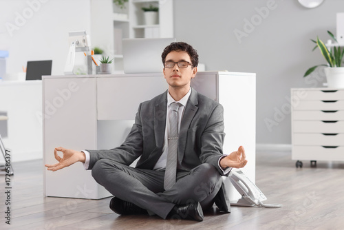 Young businessman meditatin...
