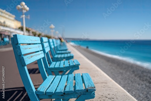 Row of bright blue chairs along a seaside promenade (1)