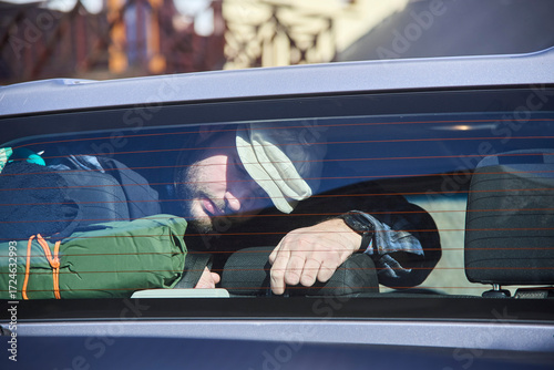 Everyday scene from a road trip, seen through the window of a traveler who is arranging their luggage or looking for something inside their truck.