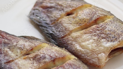 Closeu view of Fried gourami in a plate on a white background, Thai food. Side view
