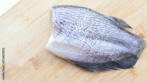 A top view of freshly cut gourami fish on a wooden board. Thai people often use it to make delicious sun dried fish dishes.