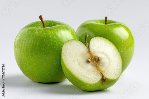 Two whole and one sliced green apple