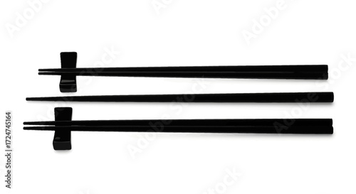 Pair of black chopsticks resting on white surface with small chopstick rests vector