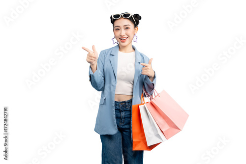 portrait Asian Woman  happy holding shopping bags and pointing her finger. She is wearing stylish outfit with a smiling face and thumbs up gesture on PNG