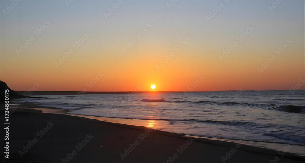 Obraz premium A vibrant sunset over the ocean, with the sun reflecting on the water and a sandy beach in the foreground.