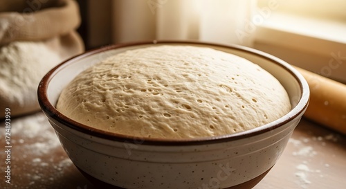 Fermented dough in ceramic bowl ready for baking, rustic kitchen scene