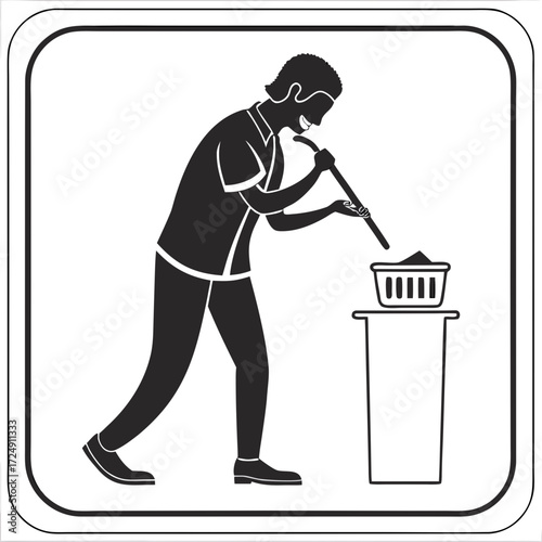 A person is shown in silhouette using a long stick to deposit material into a basket placed on top of a trash can representing waste disposal or recycling